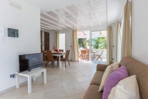 a living room with a couch and a tv at Casa Bianca in Salento in Torre Santa Sabina