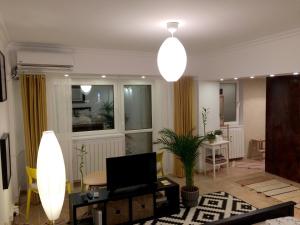 a living room with a table and a television and a room with a tablektop at My Little Studio in Bucharest