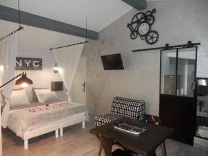 1 dormitorio con 1 cama, 1 mesa y 1 silla en Suite luxe avec sauna et jacuzzi privée, en Lambesc