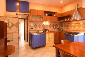 a kitchen with blue cabinets and a wooden table at Casa Chicco in Sorrento