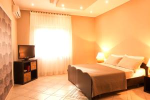 een slaapkamer met een bed, een televisie en een raam bij Casa Chicco in Sorrento