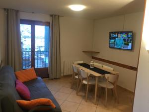 Una sala de estar con un sofá, una mesa y un televisor. en Enjoy Apartment, en Pas de la Casa