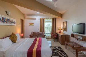 a hotel room with a bed and a television at Hotel Raha Tower in Dar es Salaam