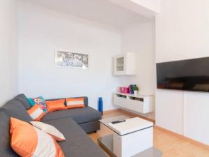 マラガにあるLarios penthouse with terrace and 2 bedroomsのリビングルーム(グレーのソファ付)、キッチンが備わります。