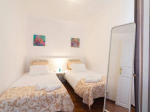 a bedroom with two beds and a mirror in it at Larios penthouse with terrace and 2 bedrooms in Málaga