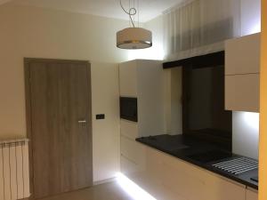 kuchnia z białymi szafkami i czarnym blatem w obiekcie Silver Residence w Rabce