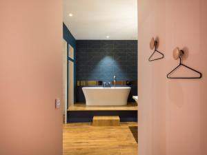 a bathroom with a tub and a sink at MiHotel Bizolon in Lyon