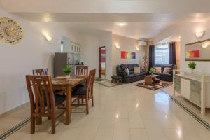 a dining room and living room with a table and chairs at Hotel Raha Tower in Dar es Salaam