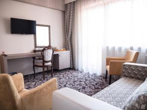 a hotel room with a desk and a chair and a mirror at Best Western Silva Hotel in Sibiu