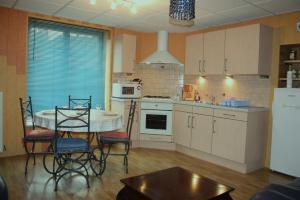 a kitchen with a table and chairs and a table and a table and a kitchen at Aux 3 Loups in Châtenois