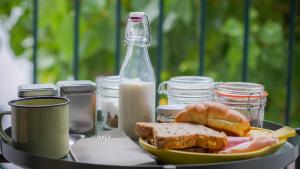 a plate of food with bread and a bottle of milk at Casa das Arcadas in Ponta Delgada