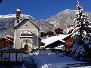 a church in the snow with a christmas tree at Haus Wiedersehn in Blitzingen