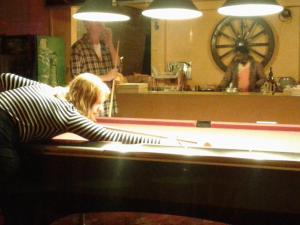 a woman sitting at a counter in a bar at King Fern Cottage in Nuwara Eliya