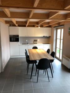 une cuisine avec une table en bois et des chaises noires dans l'établissement Beachhouse Wenduine 28, à Wenduine