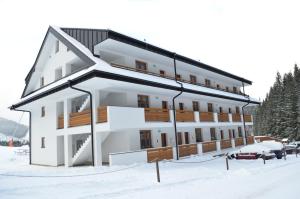 a large building in the snow with snow at Apartmán Mateo Jasná in Demanovska Dolina