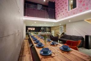 a long wooden table with plates and dishes on it at N5 Townhouse, Brighton Sleeps 20 in Brighton & Hove