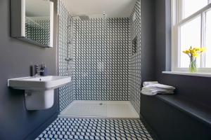 a bathroom with a sink and a shower with a mirror at N5 Townhouse, Brighton Sleeps 20 in Brighton & Hove