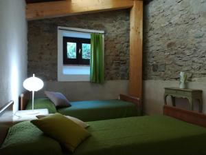 een slaapkamer met 2 groene bedden en een raam bij Il Cerro Agriturismo Zagarese in Fuscaldo