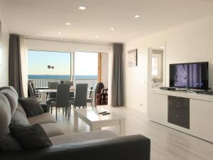 a living room with a couch and a table with a television at fantasticas vistas a mar in Pineda de Mar