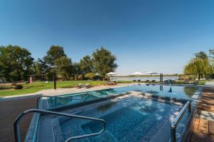 a large swimming pool with a deck and a swimming poolvisor at Donautica Hotel & Restaurant in Fadd-Dombori