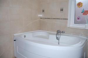 eine weiße Badewanne mit einem Wasserhahn im Bad in der Unterkunft Pensiunea Anca in Baile Felix + 38 Fotos