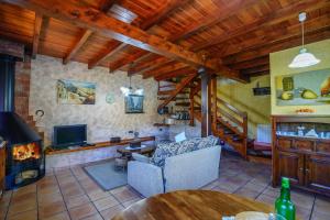 sala de estar con sofá y chimenea en Apartamentos Rurales Balcón Real Senda del Oso, en Campiello