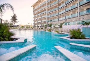 a swimming pool in front of a building at Asterias Beach Hotel in Ayia Napa