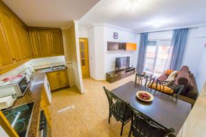 eine Küche und ein Wohnzimmer mit einem Tisch und Stühlen in der Unterkunft Homely Apartments Noruega in Torrevieja