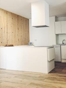 a kitchen with white cabinets and a white counter top at Apartamentos La Gloria in Benidorm