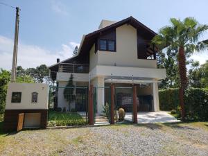 una gran casa blanca con una palmera en Casa Luxo, en Balneário Camboriú