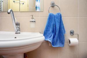 baño con lavabo y toalla azul en HostelChe Hostel, en Belgrado