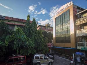 a street with cars parked in front of a building at Hotel Mount View, Siliguri in Siliguri