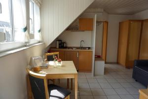 eine Küche mit einem Tisch und eine Küche unter einer Treppe in der Unterkunft Gästehaus Kiebel in Lösnich