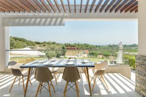 a dining room with a table and chairs on a patio at Afisia Villas in Sarti