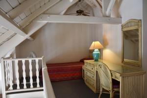 1 dormitorio con escritorio, 1 cama y espejo en Résidence Turquoise Guadeloupe - Vue mer et lagon, en Le Gosier