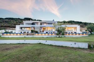 a large white house with a lawn in front of it at Afisia Villas in Sarti