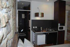 una pequeña cocina con fregadero en una habitación en Casa Dos Caldeireiros en Oporto