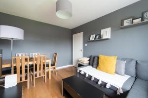 a living room with a couch and a table at Chesterton Court Apartment in Gloucester