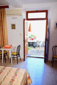 a bedroom with a door open to a table and chairs at Villa Koki Studios in Líndos