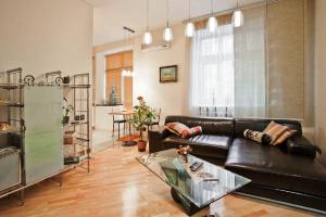 a living room with a black leather couch and a table at StudioMinsk 5 Apartments in Minsk