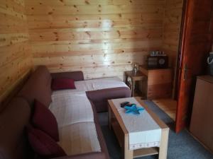 a room with two beds and a couch and a table at Woodpeckers house in Zlatibor