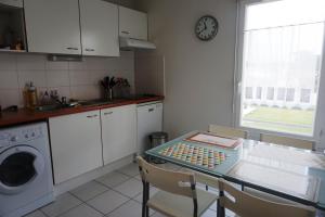 ビスカロッスにある32 RÉSIDENCE LES DEMEURES D'HECTOR -091のキッチン(テーブル、壁掛け時計付)