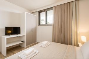a white bedroom with a bed and a television at Afisia Villas in Sarti +55 photos