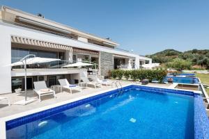 a villa with a swimming pool and a house at Afisia Villas in Sarti