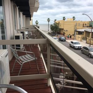 a chair on a balcony with a view of a street at Hotel Rex in Piriápolis +76 photos