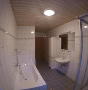 ein Badezimmer mit einer Badewanne und einem Waschbecken in der Unterkunft Haus Pistenblick in Russbach am Pass Gschütt