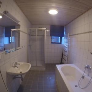 ein Badezimmer mit einem Waschbecken, einer Badewanne und einer Dusche in der Unterkunft Haus Pistenblick in Russbach am Pass Gschütt