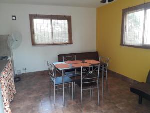a dining room with a table and chairs at Departamento Estancia Vieja 74 PB in Estancia Vieja