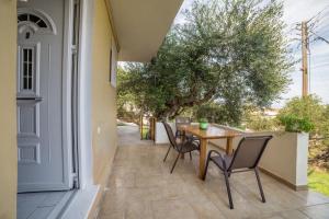 a patio with a wooden table and chairs on a house at Eleni Studios in Tsilivi