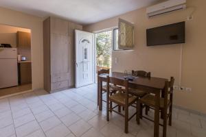 a kitchen and dining room with a table and chairs at Eleni Studios in Tsilivi